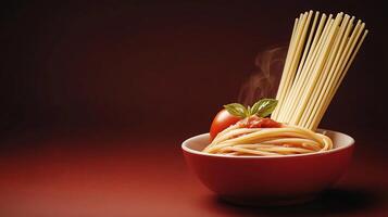 A steaming bowl of spaghetti topped with fresh basil and tomato sauce against a dark background photo