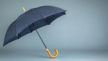 A stylish umbrella with a patterned canopy stands elegantly against a minimalist gray backdrop photo