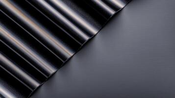 Abstract close-up of black metallic folds against a smooth dark surface, creating a sleek design photo