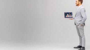 Businessman in a suit presenting digital financial graphs on a laptop in a minimalist studio setting photo