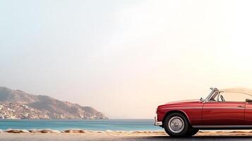Classic red convertible parked by the tranquil beach during sunset, with mountains in the background photo