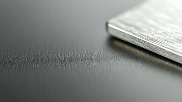 Close-up of a brushed metal surface with a sleek edge reflecting light, showcasing texture photo