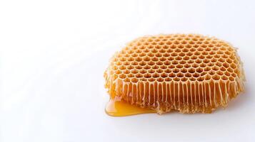 Close-up of a fresh honeycomb dripping with golden honey on a white background photo