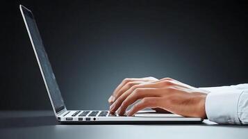 Close-up of a person's hands typing on a laptop in a dimly lit environment, focusing on productivity photo