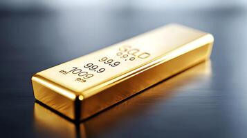 Close-up of a shiny gold bar resting on a reflective surface with soft background light photo