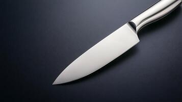 Close-up of a sleek kitchen knife on a dark surface, highlighting its sharp blade and elegant design photo