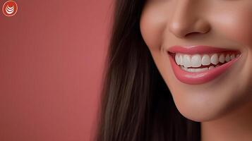 Close-up of a smiling woman with glossy lips and straight teeth against a soft pink background photo