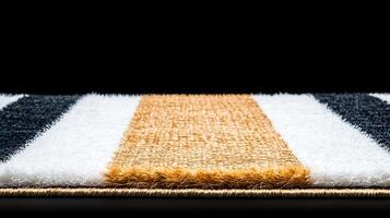 Close-up of a textured rug with striped patterns in black, white, and gold on a dark background photo