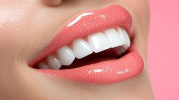 Close-up of a woman's glossy lips and bright smile against a soft pink background, showcasing beauty photo