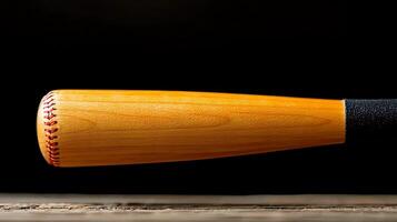 Close-up of a wooden baseball bat resting on a rustic wooden surface with a dark background photo