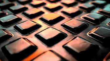 Close-up of textured metal surface with square patterns reflecting warm light tones photo