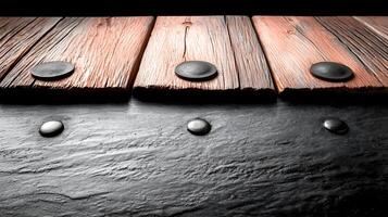 Close-up of wooden planks with smooth black stones on a dark surface, creating a serene atmosphere photo