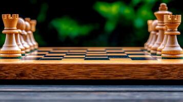 Close-up view of a wooden chessboard with pieces arranged, surrounded by a blurred green background photo