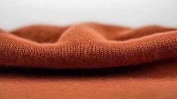 Close-up view of soft, textured fabric in warm orange hue, highlighting its intricate weave and folds photo