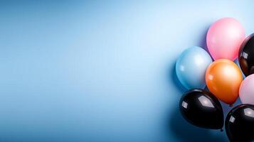 Colorful balloons in various shades clustered in the corner against a soft blue background photo