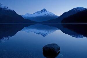 A mountain is reflected in a lake at dusk photo