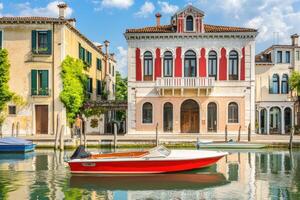 A boat is docked in front of a house on the water photo
