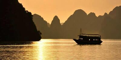 A boat is sailing on the water in front of mountains photo