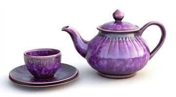 A purple teapot and cup on a white surface photo