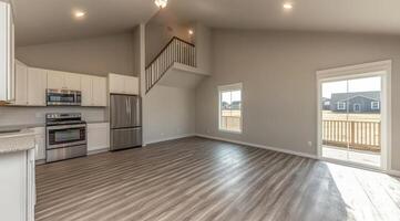 Open-concept living area with kitchen and stairs photo
