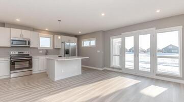 Open-concept kitchen and living area with large windows photo