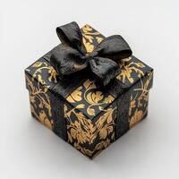 Elegant black gift box with gold patterned design and a black ribbon bow photo