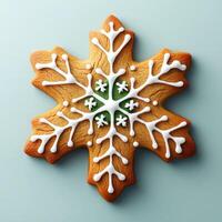 Detailed snowflake-shaped gingerbread cookie, iced with white icing and decorated with green accents photo