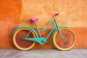 Vibrant teal bicycle leaning against an orange wall photo