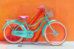 Vibrant teal bike with pink accents against orange wall photo