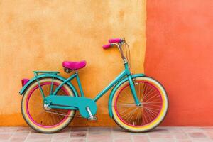 Vibrant teal bicycle against a coral and orange wall photo