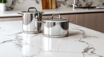 Stainless steel pots on a marble countertop in a modern kitchen photo