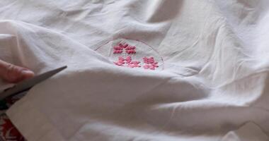 Crafting fun with a cut embroidered pattern showcasing cottagecore essence. Traditional folk motifs emerge through skilled hands, bringing vintage charm to life in a serene countryside setting. video