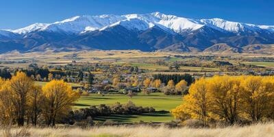 Autumnal valley nestled beneath snow-capped peaks photo