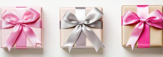 Three gift boxes with pink ribbon and silver bows photo