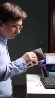 A man is looking at his wallet while sitting at a desk. empty wallet video