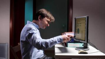 A man sitting at a desk with a computer video
