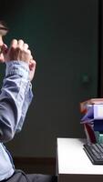 A man sitting at a desk with his hands on his head video