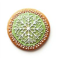 A green cookie decorated with snowflakes on a white background photo