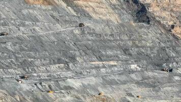 Aerial view of an expansive open pit mine with visible machinery, illustrating industrial excavation and natural resource extraction video