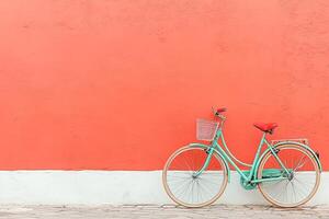 Retro teal bicycle against coral wall photo