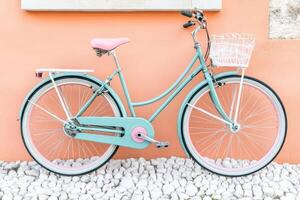 Pastel-colored bicycle parked against a peach-colored wall photo