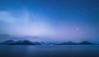 Nighttime coastal landscape with stars photo