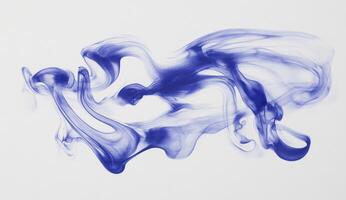 Abstract indigo ink swirling on white background photo