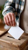 A person putting a ballot into a wooden box photo