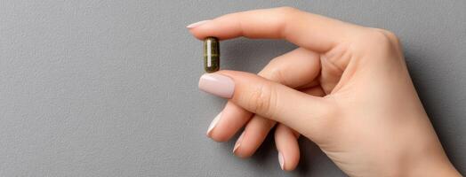 A person holding a pill in their hand photo