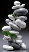 A stack of stones with leaves on top photo