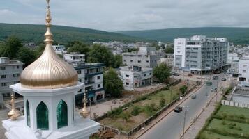 A white mosque with a gold dome in the middle of a town photo