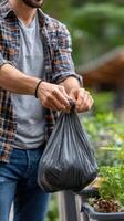 Man picking up trash in a garden photo