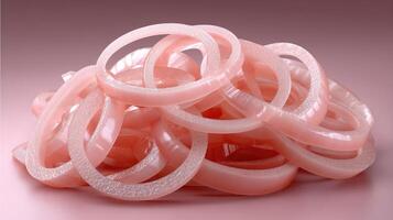 A pile of pink rubber rings on a pink surface photo