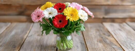 A vase filled with colorful gerberas on a wooden table photo